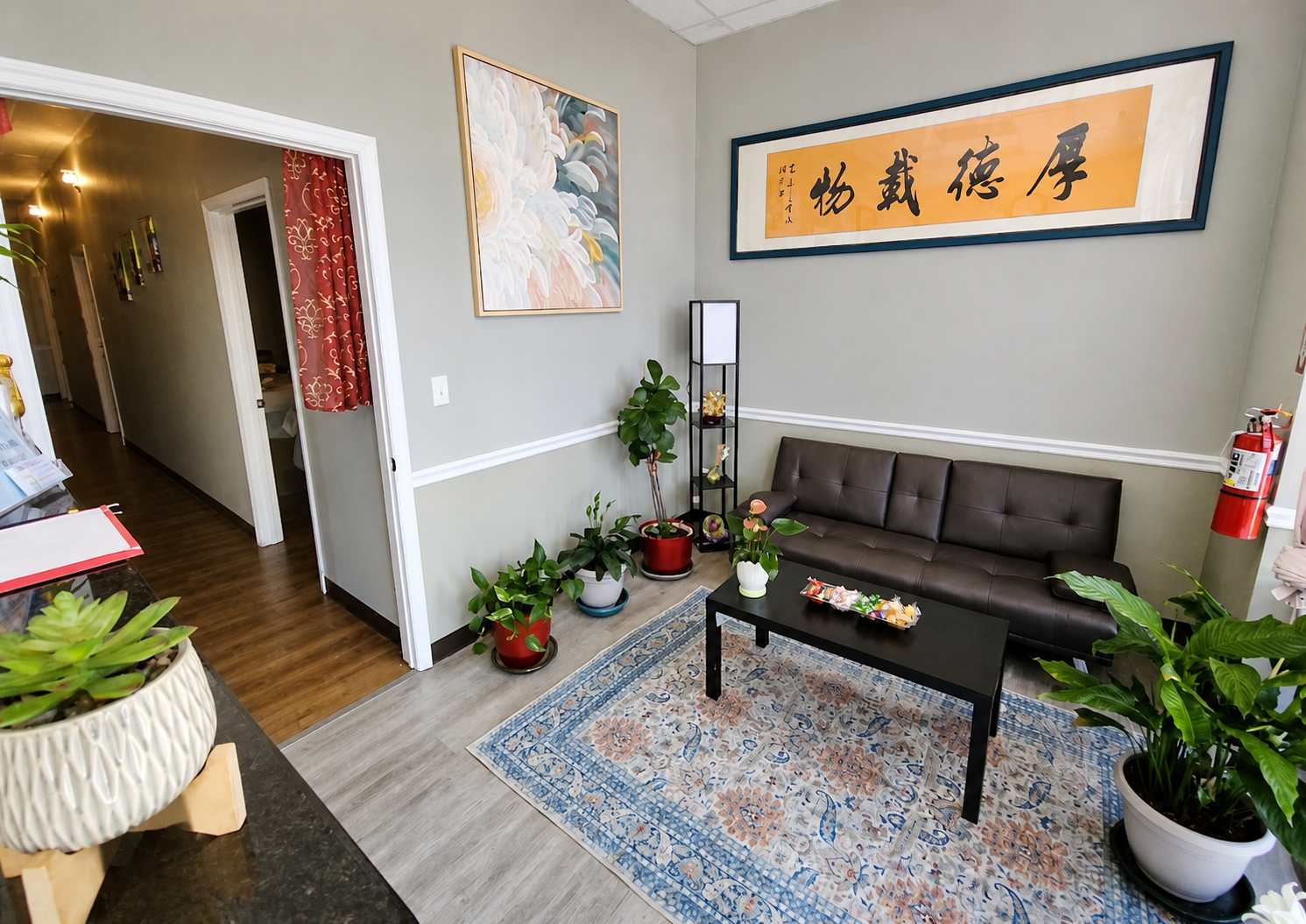 Lotus Spa reception and waiting area with plants, sofa, and traditional artwork